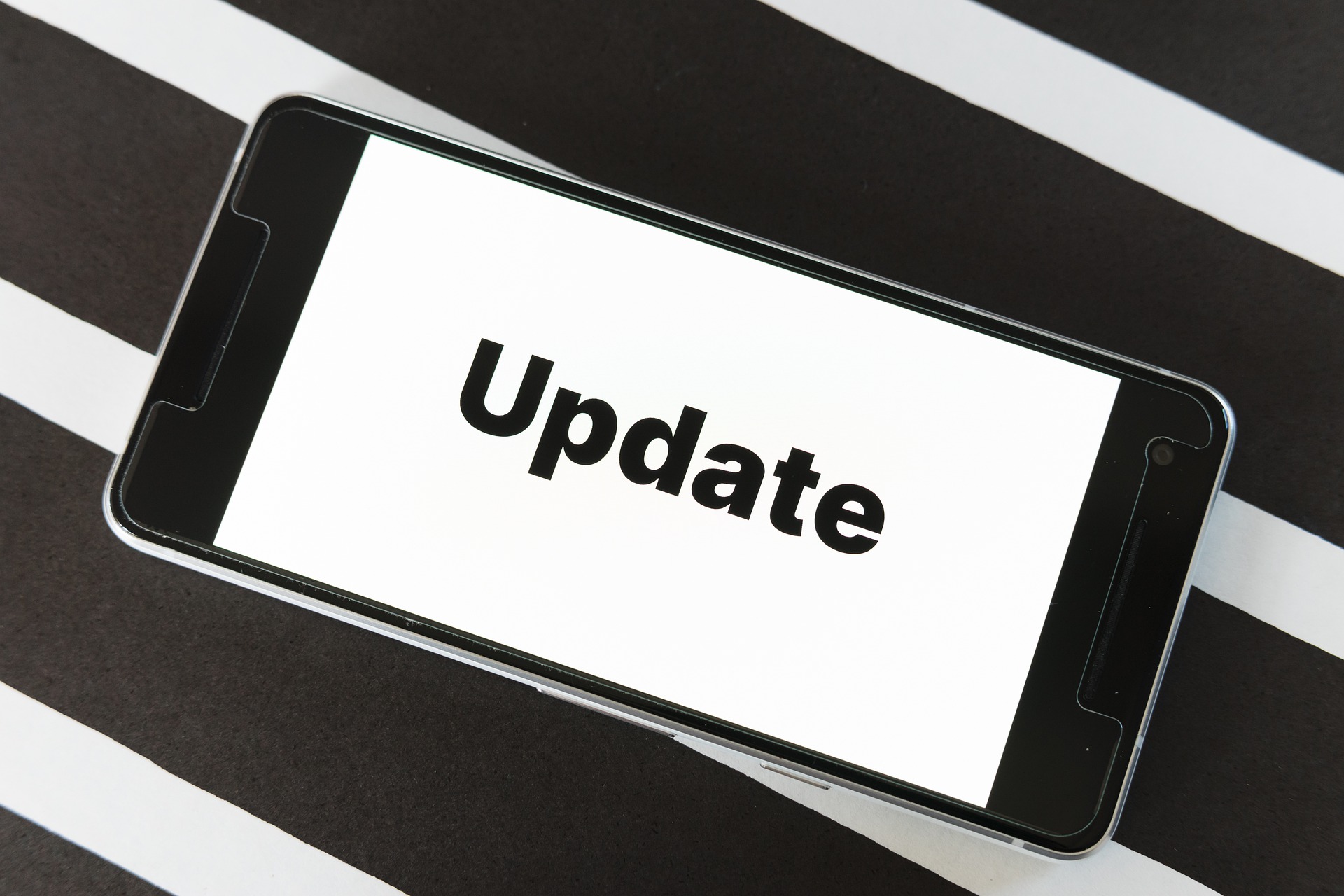 Un smartphone avec le mot Update inscrit dessus sur un fond noir et blanc.